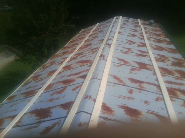 Rusted metal roof panels with new wood purlins before replacement — Storm Damage Roof Repair in Gerlach by Roofing Brothers