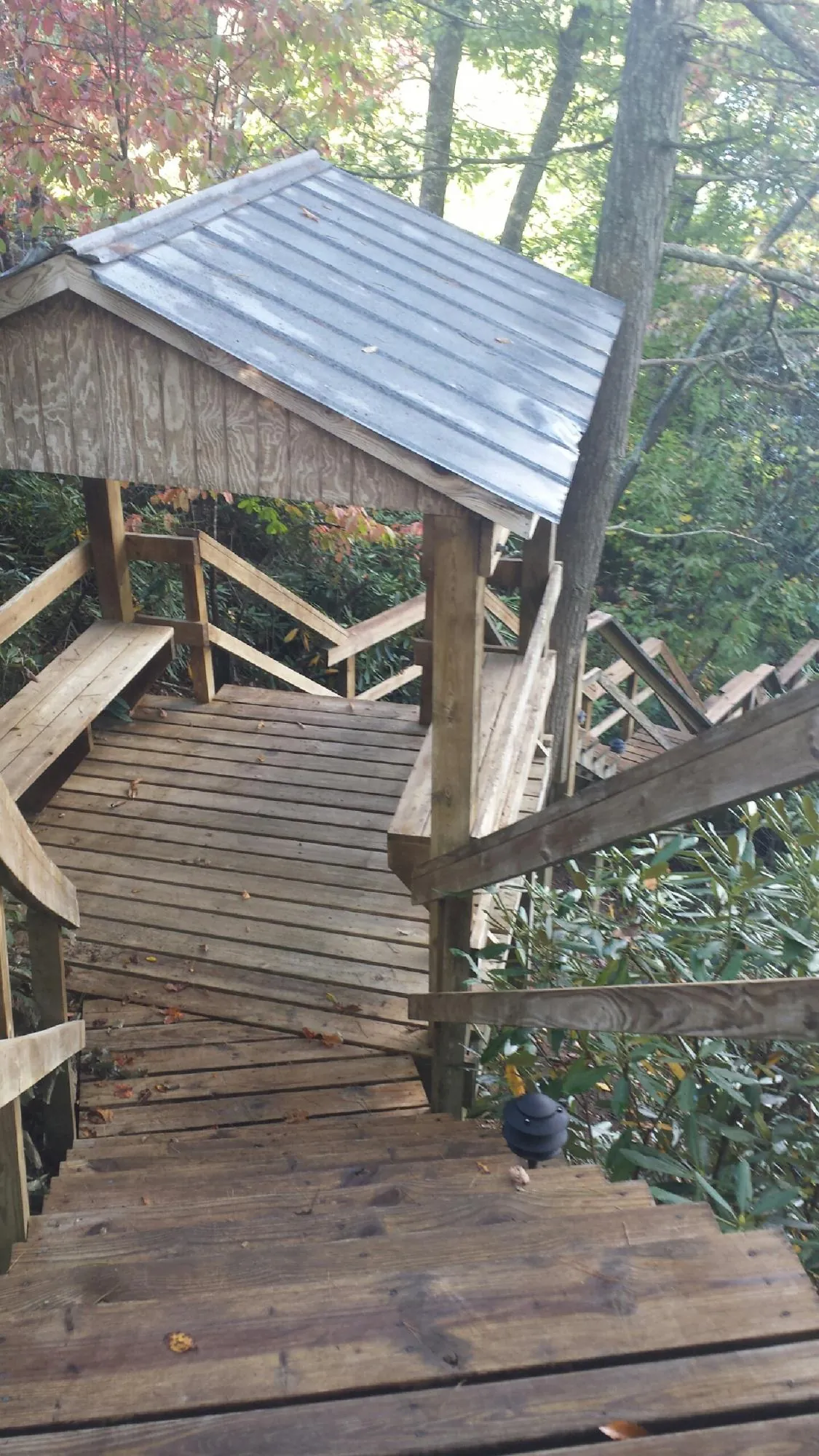 Metal roofed shelter over wooden steps on a wooded walkway — Skylight Repair & Installation work by our crew in Gerlach